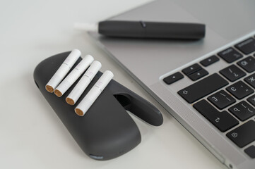 Tobacco heating system next to a laptop. 