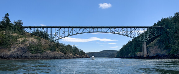 A pleasure boat transits through Deception Pass into Rosario Strait passing under the Deception...