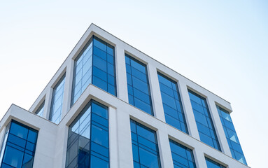 Obraz premium A tall building with many windows and a blue sky in the background