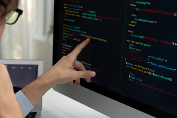 IT developer selecting by point on coding online software development information on pc comparing...