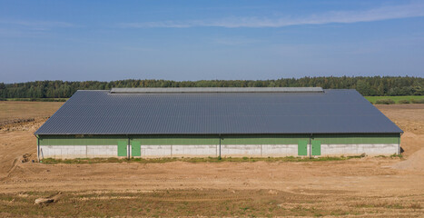 Fototapeta premium Large Green Agricultural Farm Warehouse Building on a Farm in the Countryside