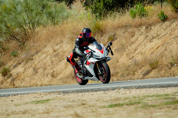 Obraz premium Motorcyclist riding sportbike on country road