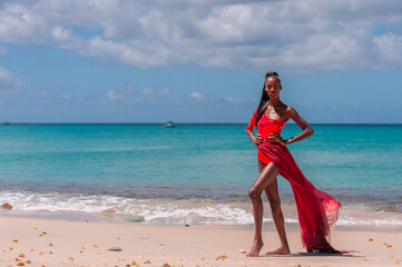 Fototapeta premium Woman Wearing Red Bikini and Dress on a tropical beach. Remote tropical beach in Barbados, Caribbean Sea