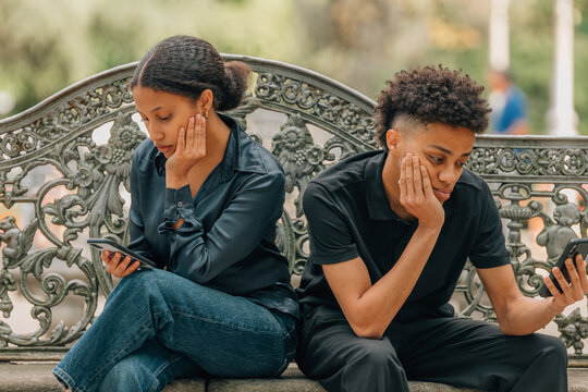young bored couple looking at their phones