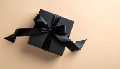 Black Gift Box with Black Ribbon on Beige Background 