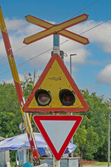 Railway crossing traffic sign with open ramp and lights outside on a street