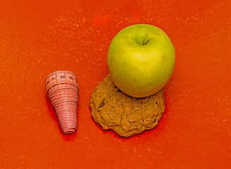 Fresh organic healthy green apple fruit on sweet cookie next to a measuring tape