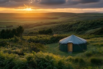 A yurt nestled in a lush green landscape at sunset offering a peaceful retreat experience