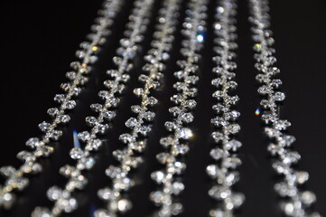 Flexible wire with shiny thinestones on black background. Shiny beaded wire for fashion design or embellishment.