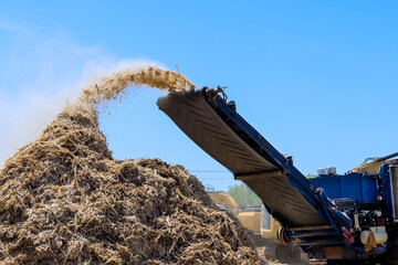 Large equipment distributes organic material at wood chip industrial activity in land clearing for...