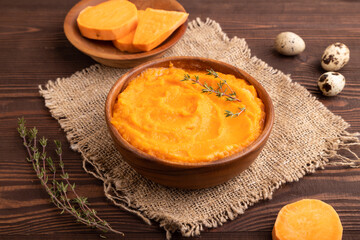 Sweet potato porridge in wooden bowl on wooden background. Diet, healthy eating. side view, close up