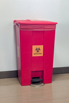 A red biohazard medical waste bin with biohazard symbol