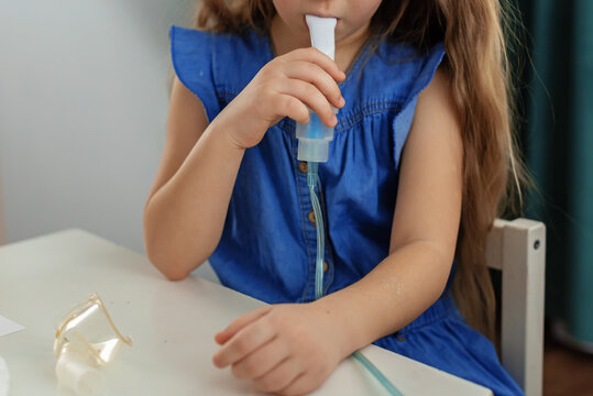 Young caucasian girl using medical inhaler for respiratory treatment
