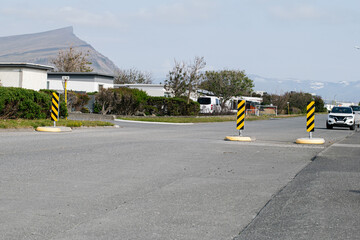 Residential street with traffic markers and mountain backdrop in Akranes, Iceland
