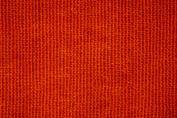 Closeup of orange ribbed corduroy fabric texture
