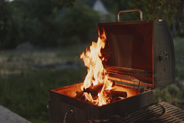 BBQ grill with flames in a backyard setting, showcasing summer cooking, outdoor dining, and vibrant...