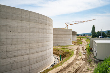 Neubau einer modernen Biogasanlage, riesige neuerbaute Betonbehälter auf einer Baustelle.