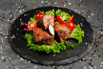 juicy golden grilled barbecue meat with spices on dark background