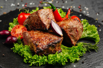 juicy golden grilled barbecue meat with spices on dark background