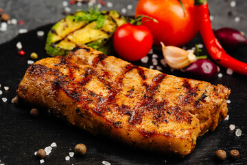 juicy golden grilled barbecue meat with spices on dark background