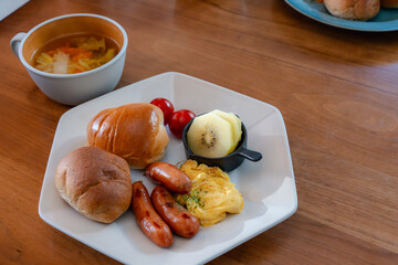 Western-style breakfast with bread, sausage, scrambled eggs and golden kiwi フルーツ付き洋風朝食