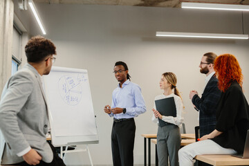 Business team analyzing pie chart during presentation in modern office