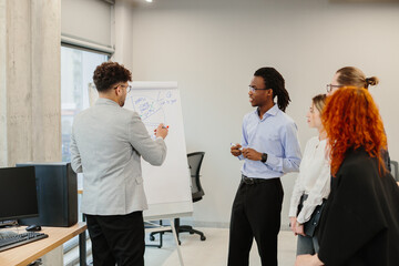 Business team analyzing data on whiteboard during office presentation