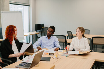 Business people working together on a project in modern office: discussing strategy and brainstorming new ideas