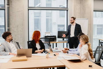 Obraz premium Business team meeting: manager leading a presentation in modern office