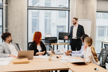 Manager leading a business meeting with his team in the office
