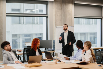 Obraz premium Business team meeting in modern office with manager leading presentation