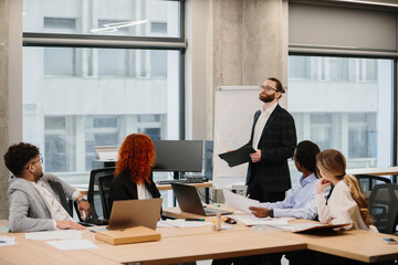 Businessman leading a presentation to his diverse team in modern office