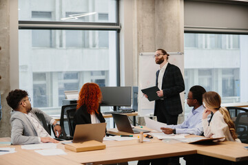 Business team meeting in modern office with manager leading presentation