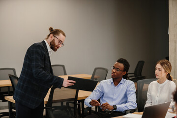 Business meeting: manager showing a report to his team in the office