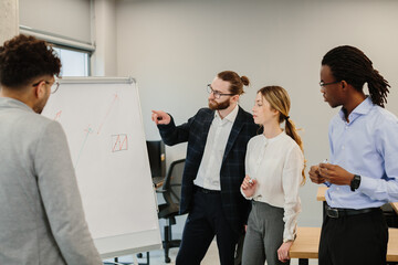 Business team analyzing growth charts on whiteboard during meeting