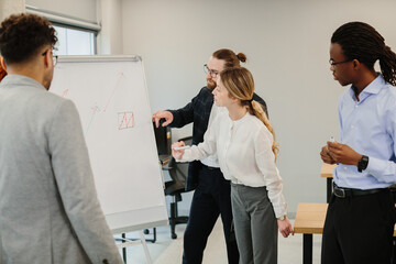 Business people analyzing growing statistics on whiteboard during presentation