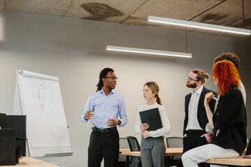Business team analyzing pie chart during presentation in modern office
