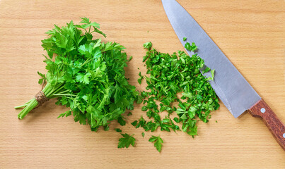 A top down view of chopped parsley on a wooden cutting board. Close up.
