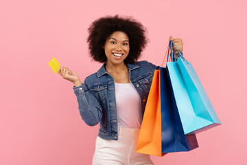 Portrait of young Black woman with colorful shopping bags and yellow credit card, african american...