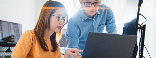 Asian male, female programming developer work together at home office, brainstorm discussion. Information technology, software engineer programmer coding job, man and woman coworker teamwork concept