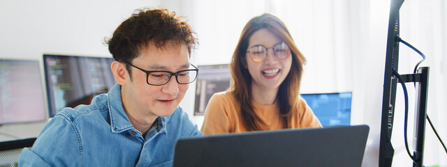 Asian male, female programming developer work together at home office, brainstorm discussion. Information technology, software engineer programmer coding job, man woman coworker teamwork. Happy smile
