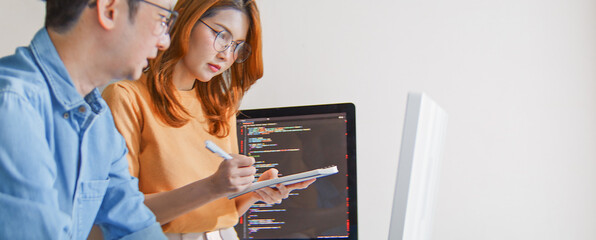 Asian male, female programming developer work together at home office, brainstorm discussion. Information technology, software engineer programmer coding job, man woman coworker teamwork. Copy space