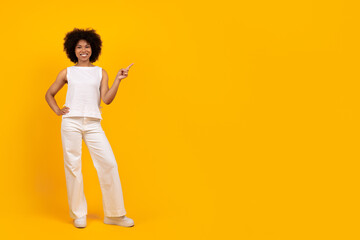 Check This. Positive cheerful beautiful young african american female in white outfit showing copy...