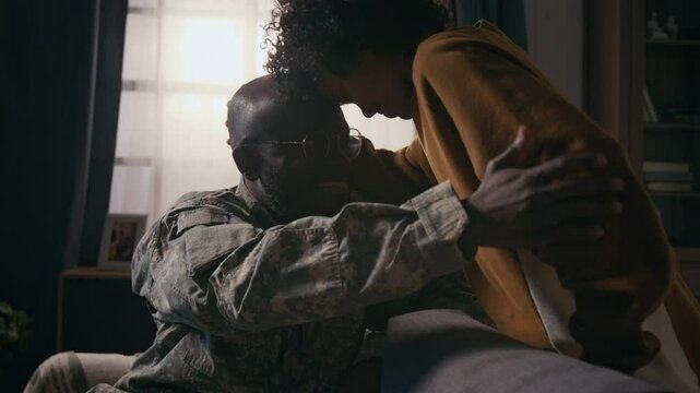 Medium shot of loving African American male army officer in military uniform and young son hugging and touching foreheads, happy at seeing each other after long service mission
