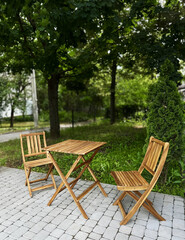 Outdoor wooden table and chairs in green park setting