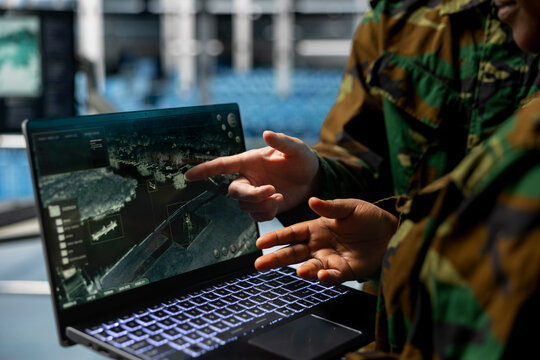 Close up of army experts in data center analyzing infrared surveillance feed on tactical interface. Military units operating real time satellite reconnaissance from secure server room - Powered by Adobe