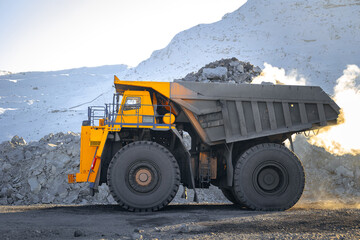 Big yellow dump truck in winter coal mine landscape, banner mining