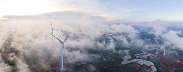 Wind Power Generation amidst misty landscape in Da lat, Vietnam. Panorama landscape of industry and...