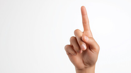 Female hand with raised index finger pointing upward against a neutral background.
