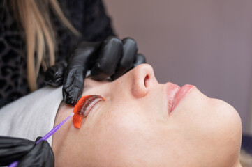 Caucasian woman undergoing eyelash lamination procedure. 